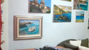 Un comedor con una mesa, un plato de comida y varios cuadros en la pared.