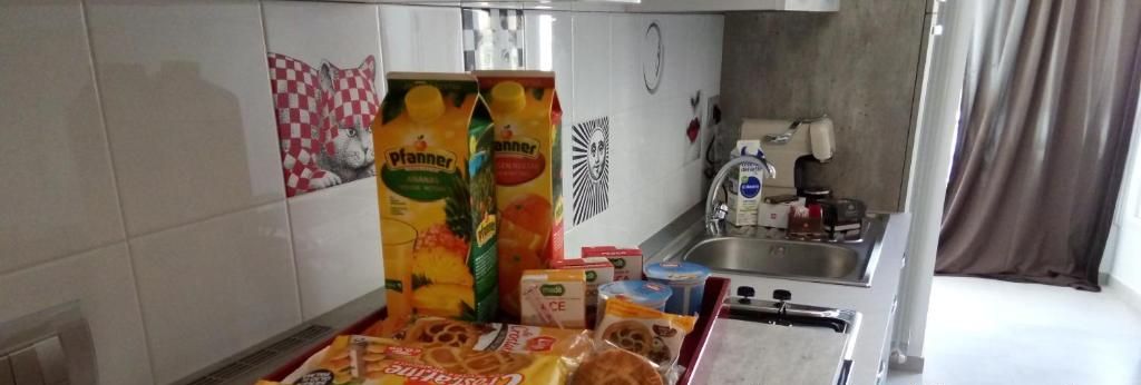 Una cocina con una bandeja de aperitivos que incluye barras de chocolate y gofres, y una nota sobre el reemplazo de vales debido a las normas de COVID.