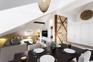 A modern loft apartment with a dining area, living space, and kitchen.