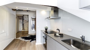 A modern kitchen with a stainless steel sink, a built-in oven, and a sleek countertop. - Madalena Downtown Luxury Duplex (Lisbon)