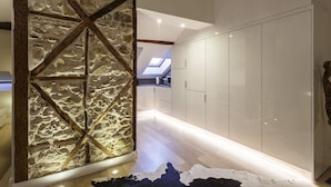 A modern interior with stone wall accents, a skylight, and a polished wood floor. - Madalena Downtown Luxury Duplex (Lisbon)