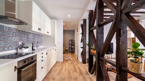 Eine Küche mit weißen Schränken, einer gefliesten Spritzschutzwand und Holzböden.