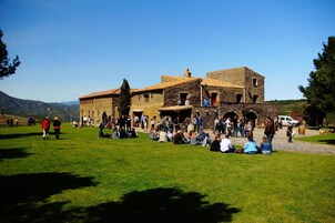 Um edifício de pedra com um pátio, cercado por visitantes.