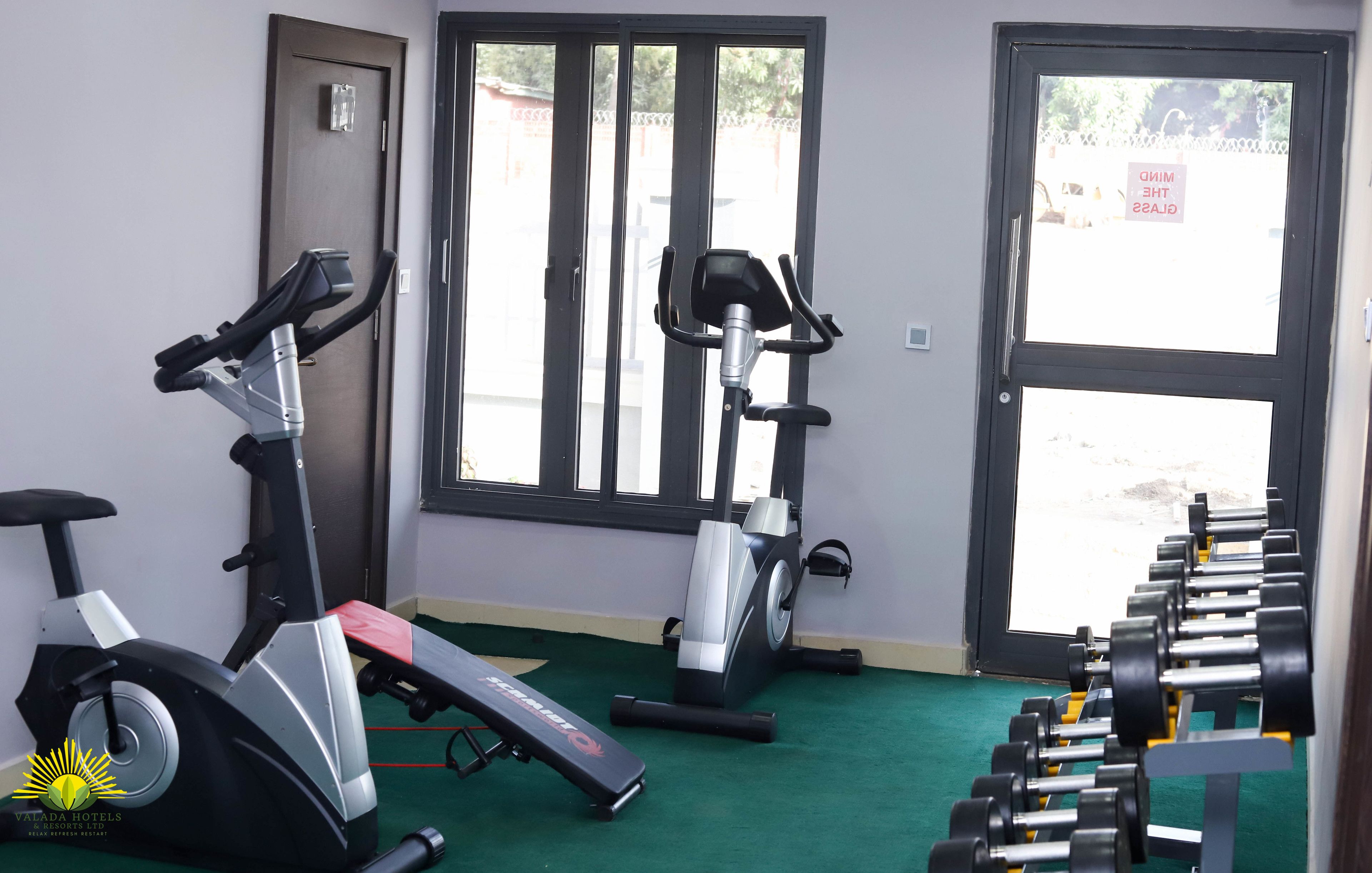 Une salle de sport équipée de matériel d’exercice, d’un banc et d’un porte-haltères.