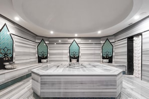A modern bathroom with a marble vanity, geometric wall tiles, and recessed lighting.