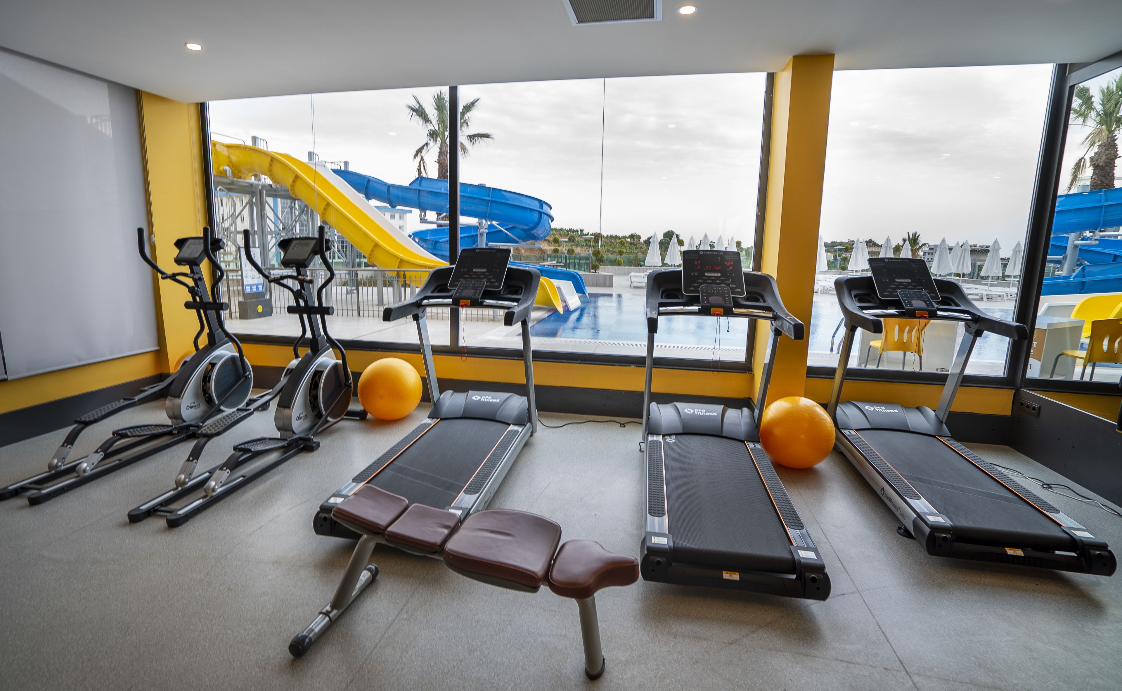 A gym with treadmills, stationary bikes, and rowing machines.