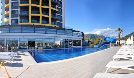 Una piscina techada, una piscina al aire libre de temporada, sombrillas