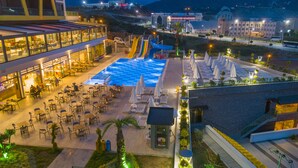Un hotel con piscina sul tetto, zona pranzo all'aperto e vista sulla città circostante.