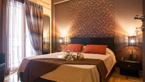 A neatly made bed with a headboard, a bedside table with a lamp, and a window with curtains. - Gold and Blue Luxurious Apartment (Athens)