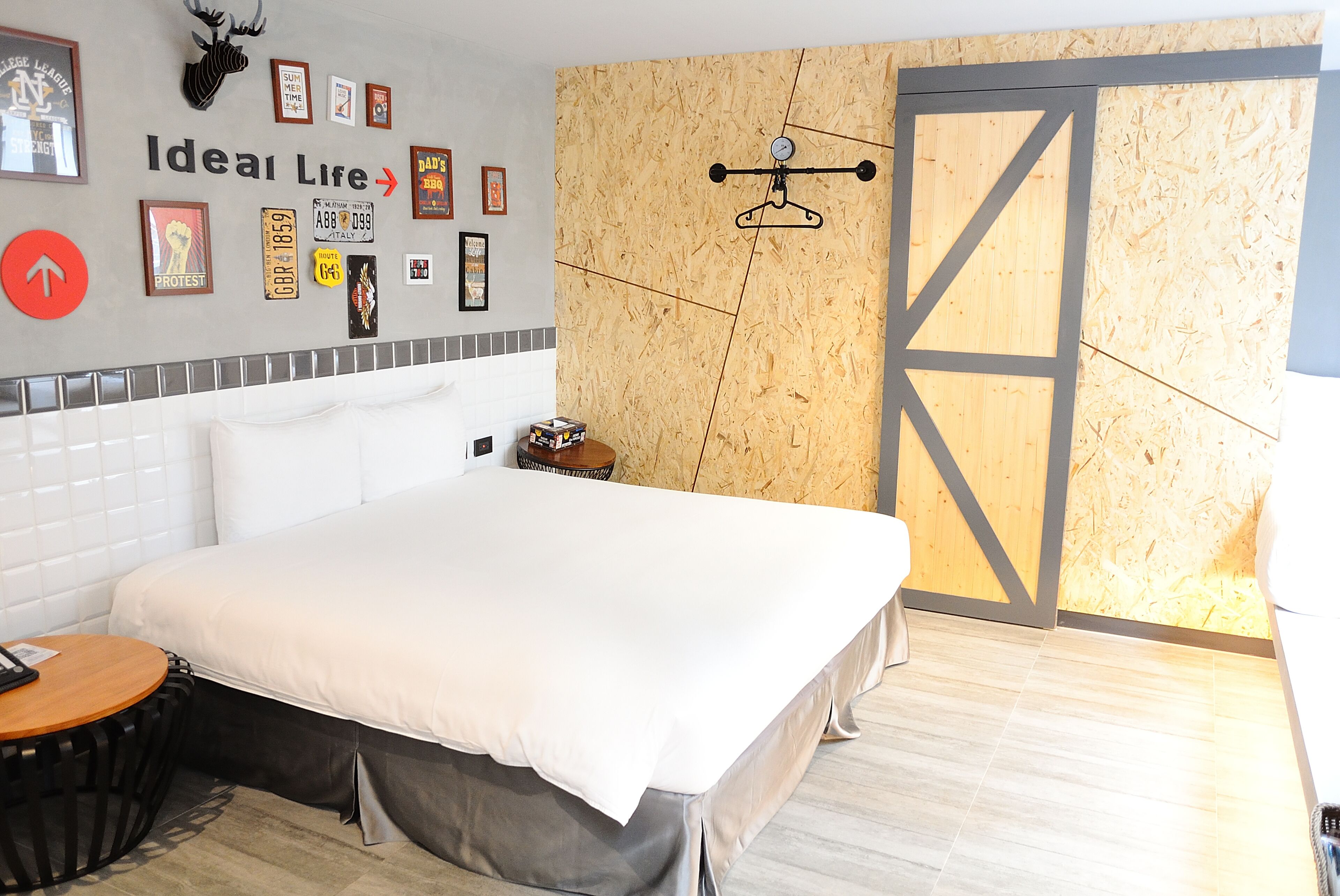 Una habitación de hotel moderna con una cama grande, un panel de madera decorativo y un perchero de pared.