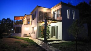 A modern two-story house with a balcony, a covered patio, and a stone pathway leading to the entrance. - 240 sqm, large pool, 300m to the beach, fantastic sea views, 2 kitchens, air conditioning (Neo Klima)