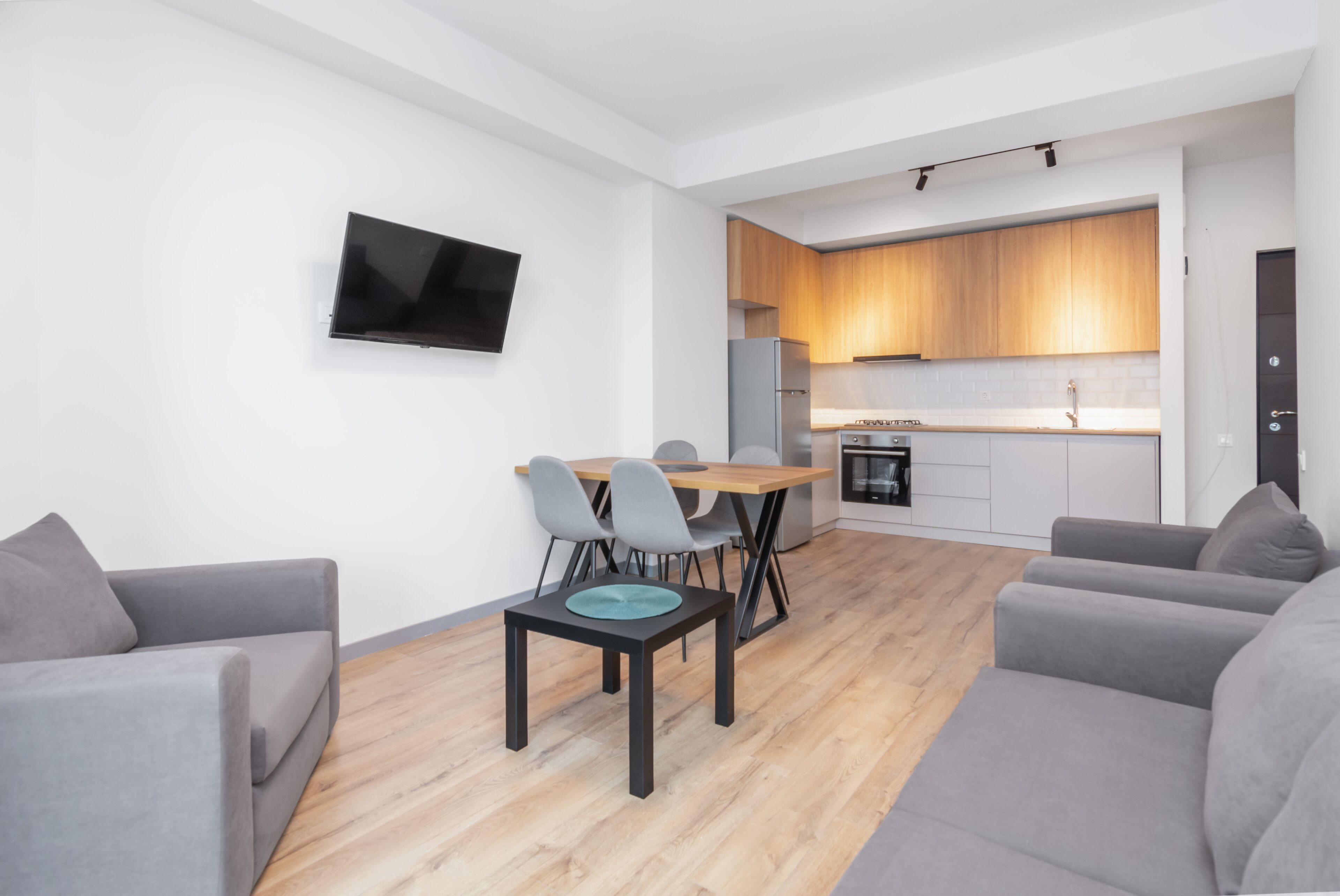 A modern apartment with a dining area, kitchen, and living room.
