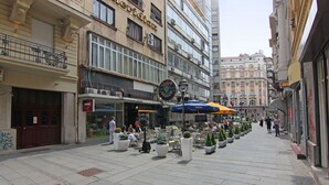 Una strada pedonale fiancheggiata da caffè e tavolini all'aperto, con negozi e edifici su entrambi i lati.