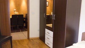 Una camera da letto con un'armadiatura in legno, un letto e un tavolino con una sedia.
