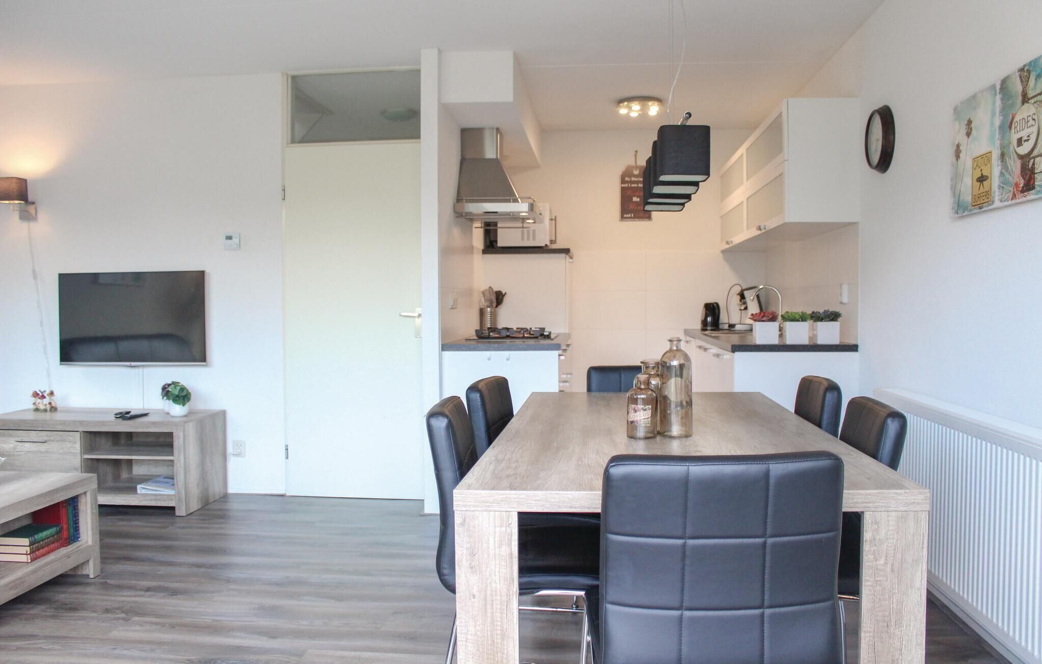 A modern kitchen with white cabinets, a built-in microwave, and a stainless steel range hood.