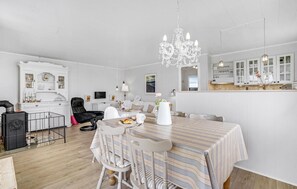 Relax in this stylish living space with a dining table, comfortable seating, and a flat-screen TV.