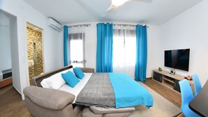 A modern hotel room with a bed, a sofa, a TV, and a desk. - Zenbeach 1A playa Carihuela (Torremolinos)