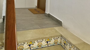 A hallway with a wooden door, a doormat, and a tiled floor. - Zenbeach 1A playa Carihuela (Torremolinos)