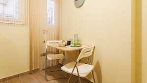 A small dining area with a table, chairs, and a clock on the wall. - Central cozy apartment (Athens)