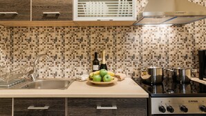 A kitchen with a sink, stove, and a decorative tile backsplash. - Central Quiet Safe Apartment (Athens)