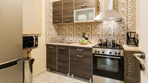 A compact kitchen with a microwave, stove, and sink. - Central Quiet Safe Apartment (Athens)