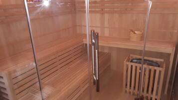 Sauna, jossa on puiset lauteet ja lasiovi.