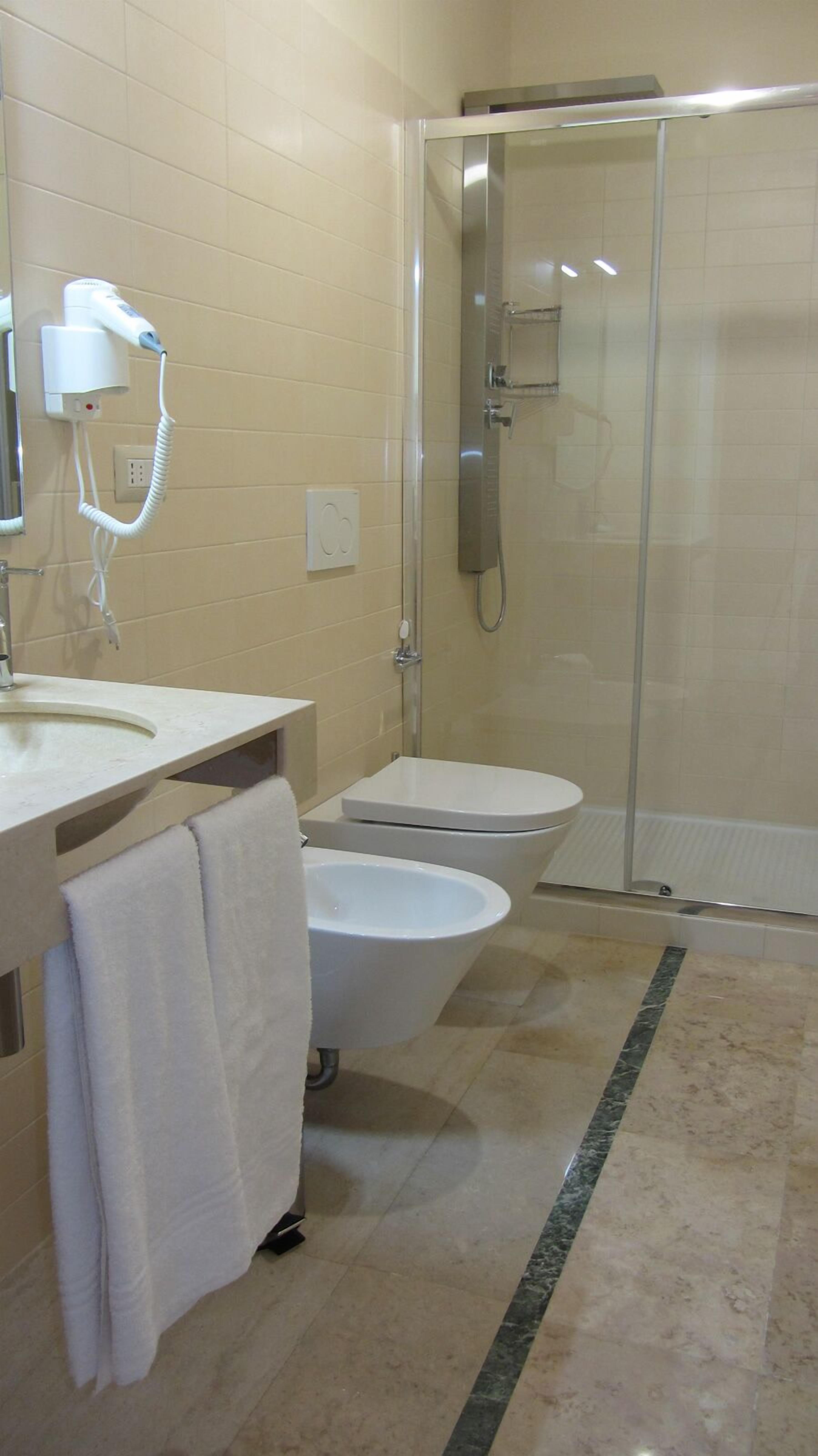 A bathroom with a sink, toilet, and shower.