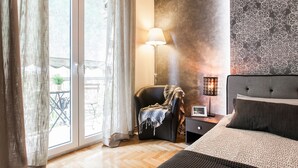 A bedroom with a bed, a nightstand, a lamp, and a chair. - Beautiful Safe Apartment Near Centre (Athens)
