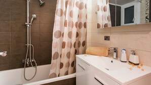 A bathroom with a bathtub, shower, and sink. - Beautiful Safe Apartment Near Centre (Athens)