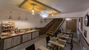 A breakfast area with a counter, seating, and a staircase. - Pensiunea Kant (Sibiu)