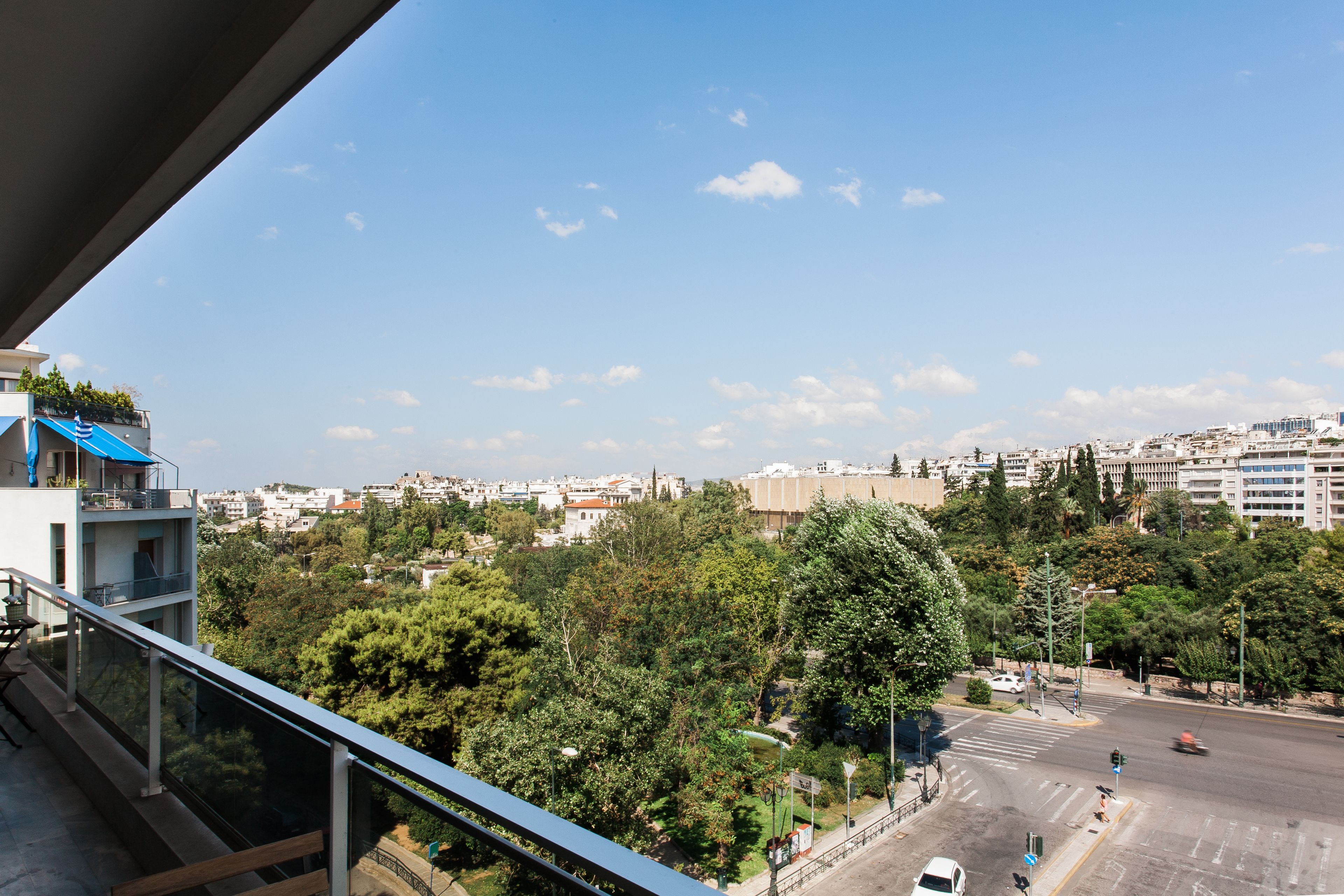 Stadtansicht mit Blick auf Gebäude, Bäume und eine Straße.