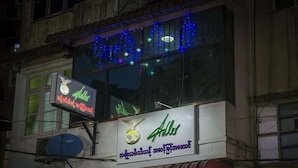 A building with a neon sign for 'Alders' and a satellite dish. - Adler Lady Guesthouse - Women Only (Yangon)