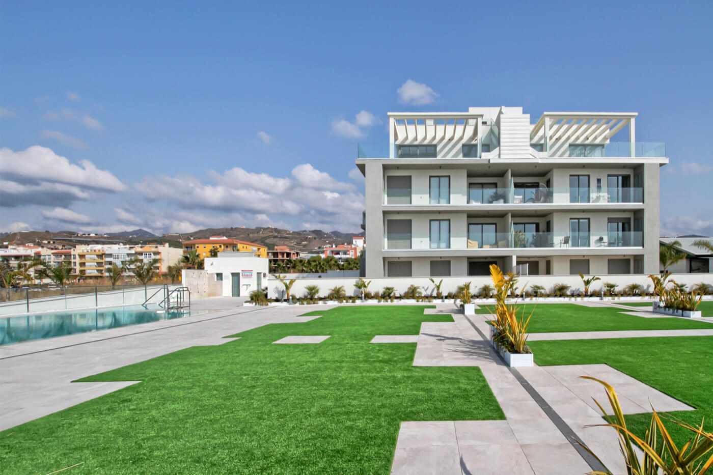 Ein modernes Hotel mit Pool, Rasenfläche und Blick auf die Umgebung.