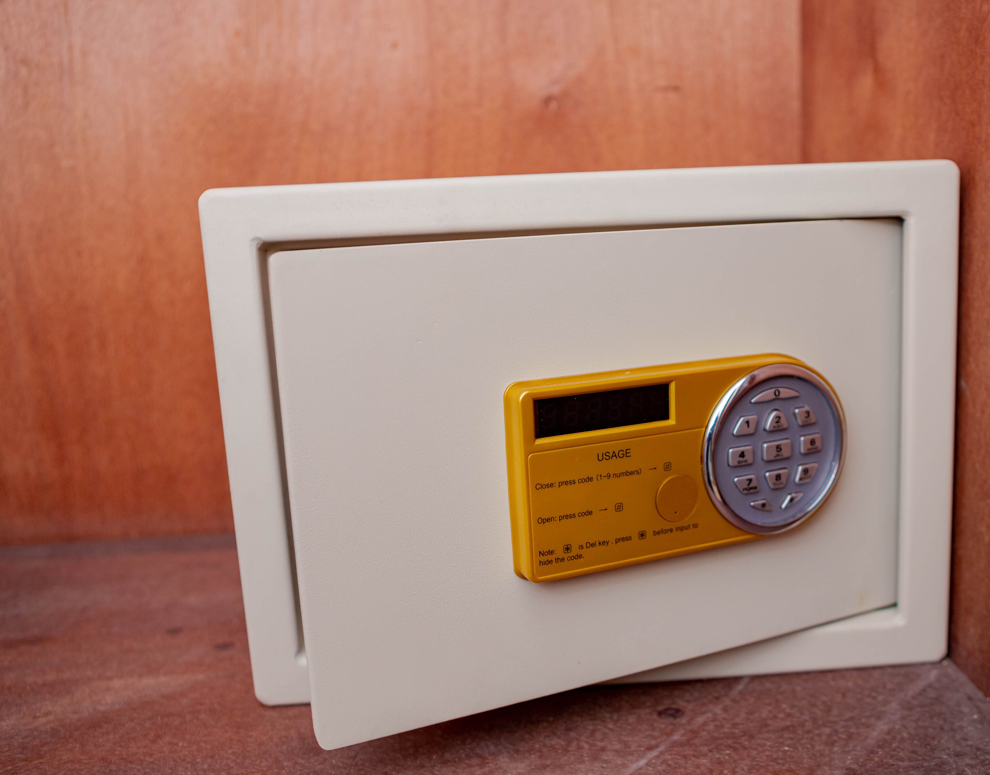 A safe with a yellow keypad and instructions for usage.