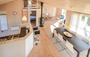 Relax in this spacious living area with a sofa, chairs, dining table, and kitchenette.