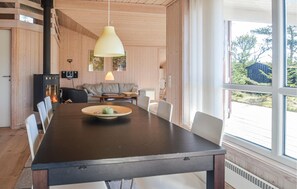 Enjoy meals in this spacious dining area with a long table, pendant light, and views of the outdoors.