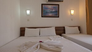 A hotel room with two beds, a painting of the ocean, and two wall-mounted lights. - Monna Roza Beach Resort Hotel (Kemer)