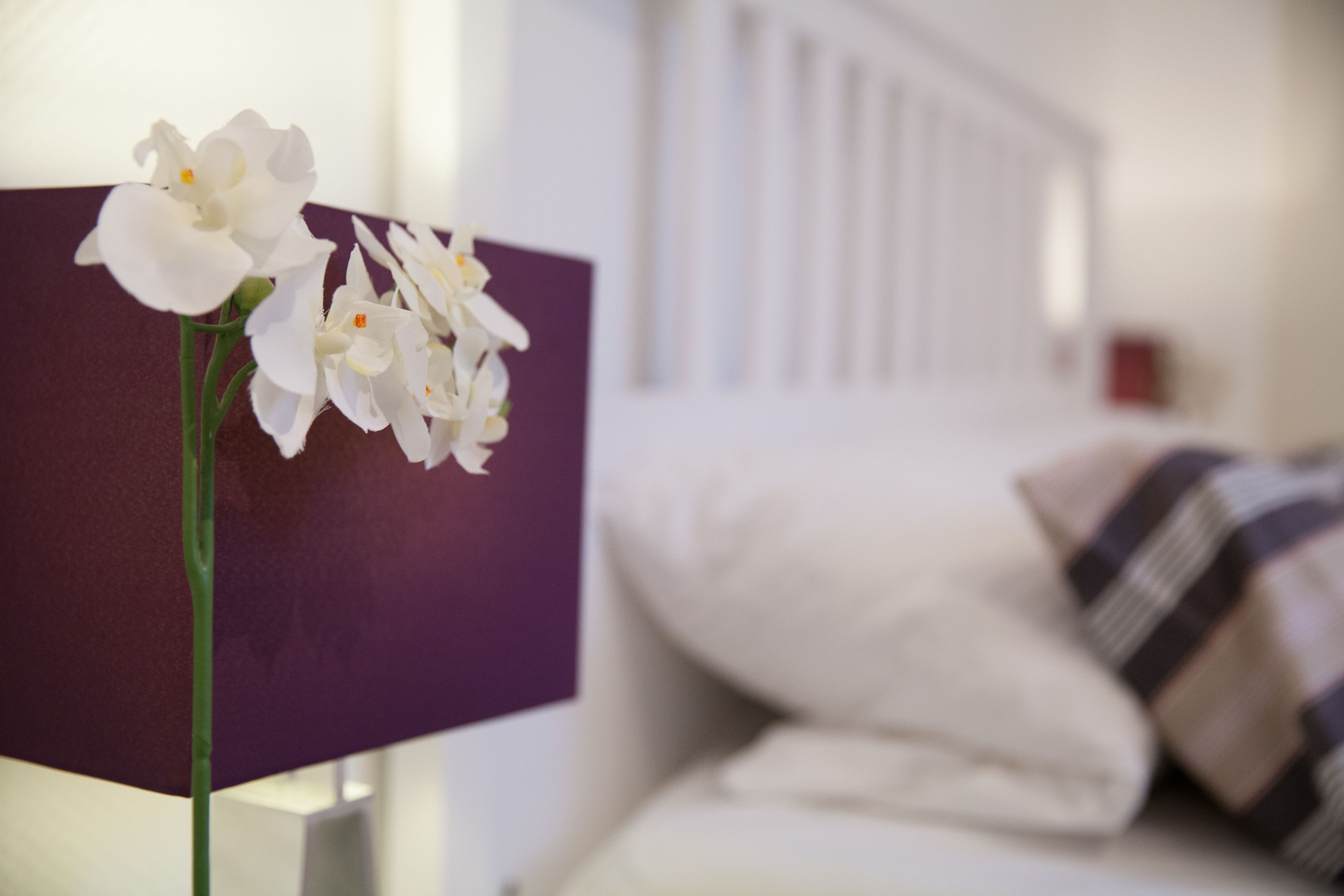 A bed with white bedding and a striped pillow.
