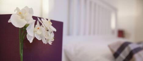 A bed with white bedding and a striped pillow.