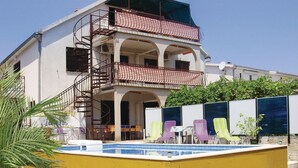 A two-story building with a balcony, a pool, and outdoor seating. - Nice apartment in Okrug Gornji with WiFi (Okrug Gornji)