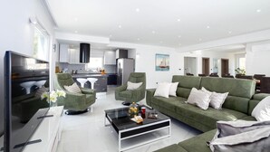 A modern living room with a green sofa, a glass coffee table, and a TV. - Cozy home in Zrnovnica (Zrnovnica)