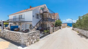 A two-story building with a stone wall, a balcony, and a staircase leading to the upper floor. - 2 bedroom gorgeous apartment in Okrug Gornji (Okrug Gornji)
