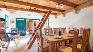 Un vaste espace dédié à la salle à manger, avec des meubles en bois et un escalier central.