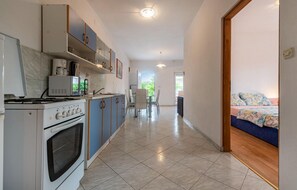 Enjoy a well-equipped kitchen with a stove and oven, and a dining area with a glass table and chairs.