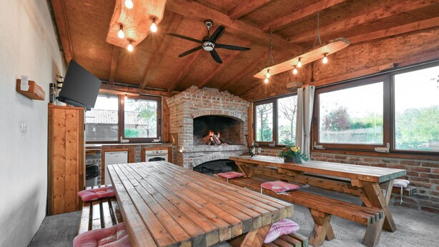 Un rustico chalet con camino, mobili in legno e ampie finestre.