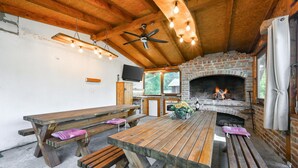 Un'accogliente interni in legno con un camino, panche di legno e una ventola a soffitto.