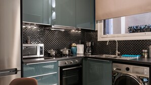 A modern kitchen with stainless steel appliances, a built-in oven, and a dishwasher. - Central Safe Smart Apartment (Athens)