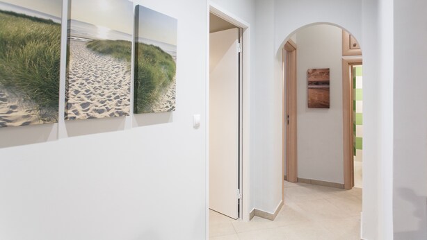 A hallway with a white wall and a door leading to another room. - Central Safe Smart Apartment (Athens)