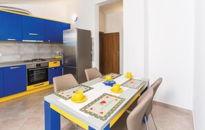 Enjoy meals in this cozy kitchen with a dining table for two, equipped with a refrigerator, oven, and gas stove.