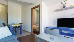 Une chambre d’hôtel moderne équipée d’un lit, d’un bureau, d’une télévision et d’un coin repas.
